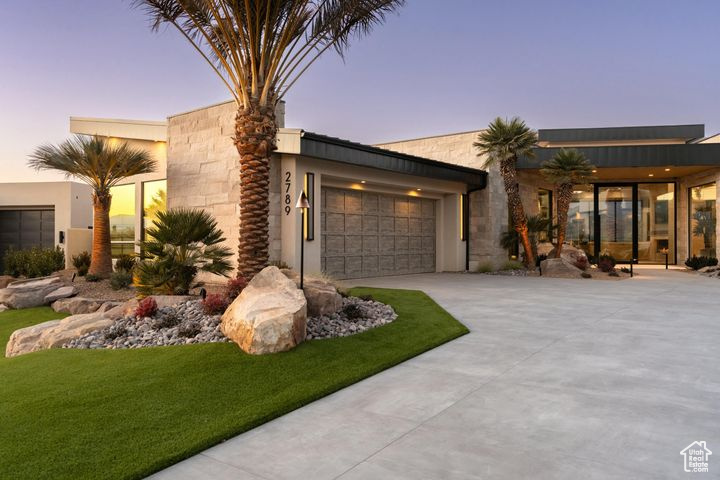 Contemporary house featuring a garage and a lawn