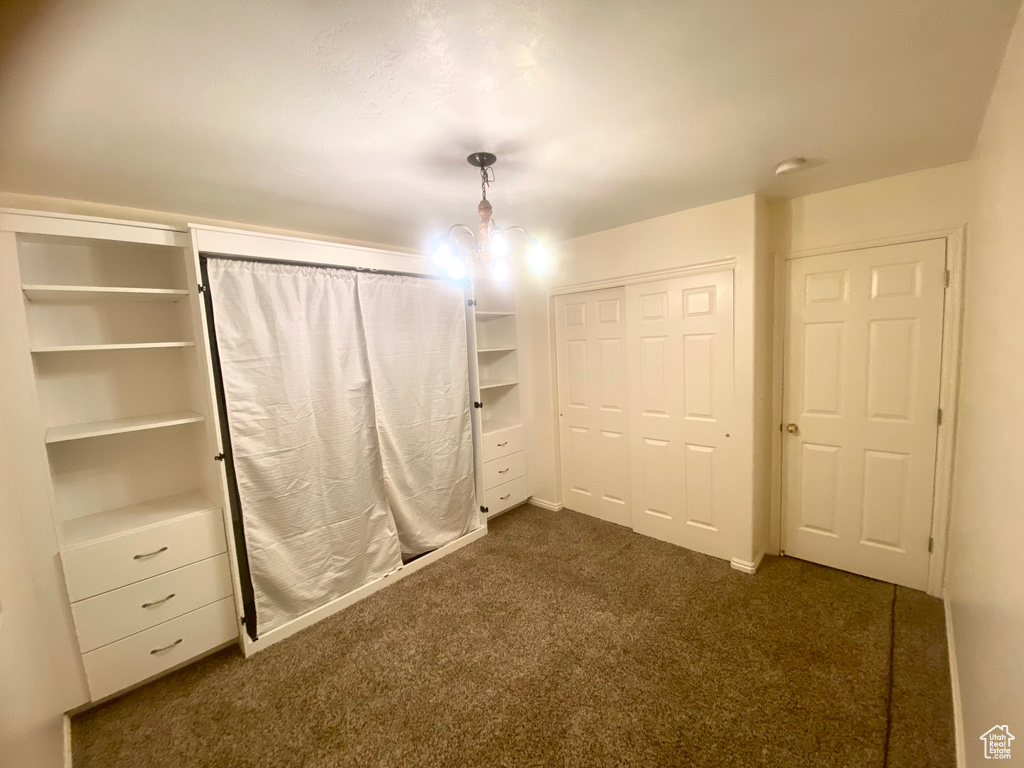 Unfurnished bedroom with dark colored carpet and a closet