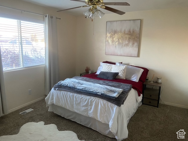 Bedroom with dark carpet and ceiling fan