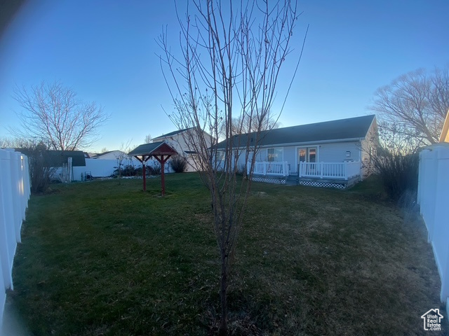 View of front of home featuring a wooden deck and a front yard