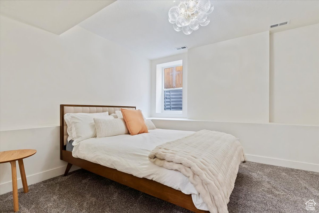 Carpeted bedroom featuring a chandelier