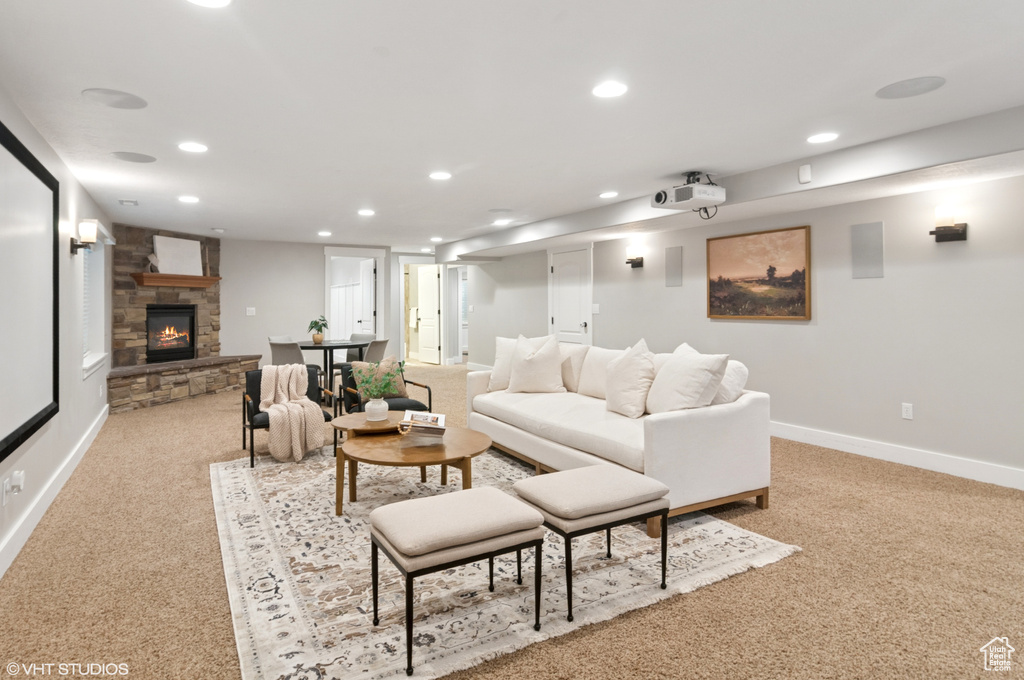Living area with recessed lighting, baseboards, light colored carpet, and a fireplace