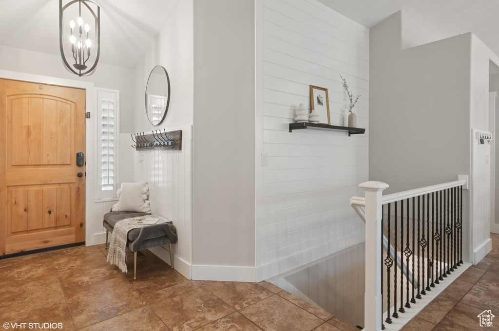 Entryway with baseboards and a chandelier