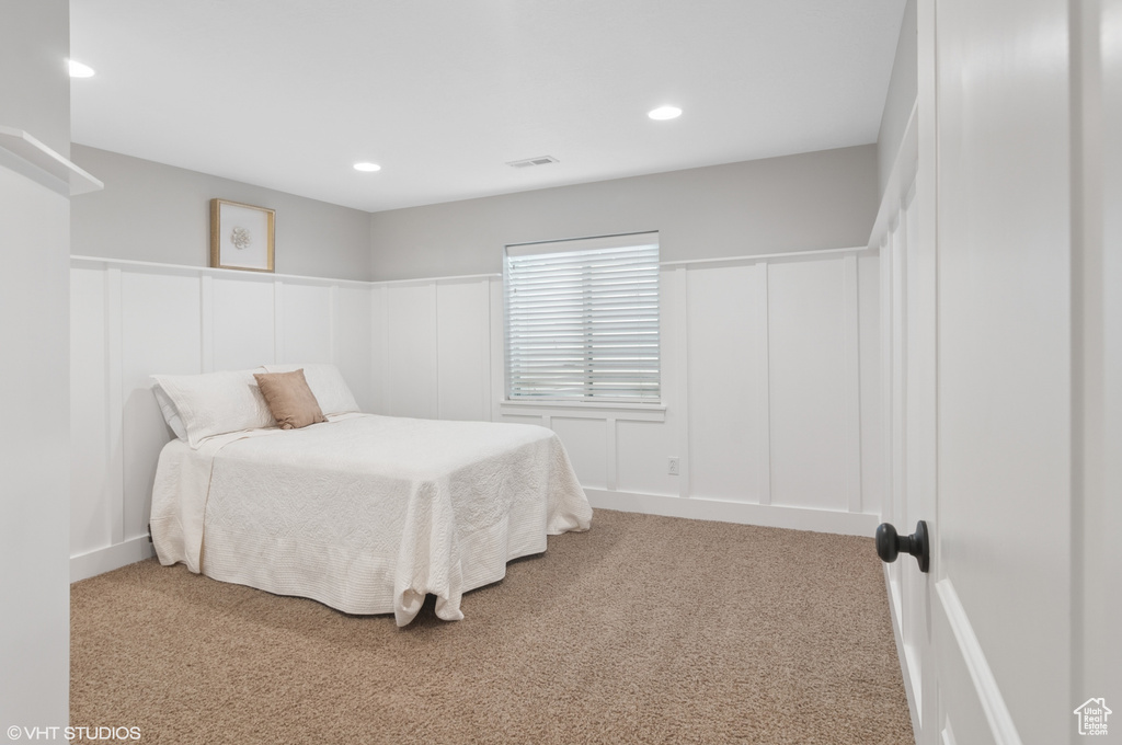 Bedroom featuring recessed lighting, visible vents, carpet floors, and a decorative wall