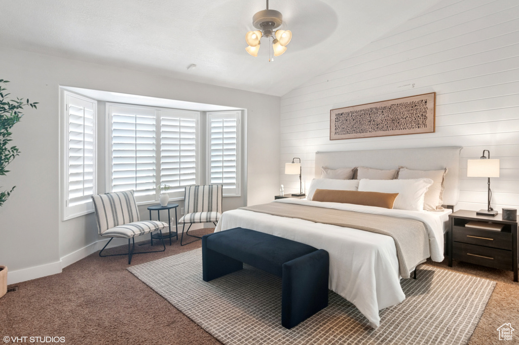 Carpeted bedroom with baseboards and lofted ceiling