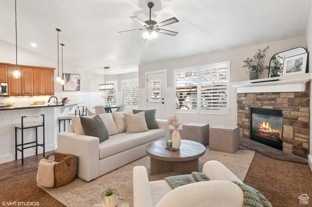 Living room with a ceiling fan, a fireplace, and wainscoting