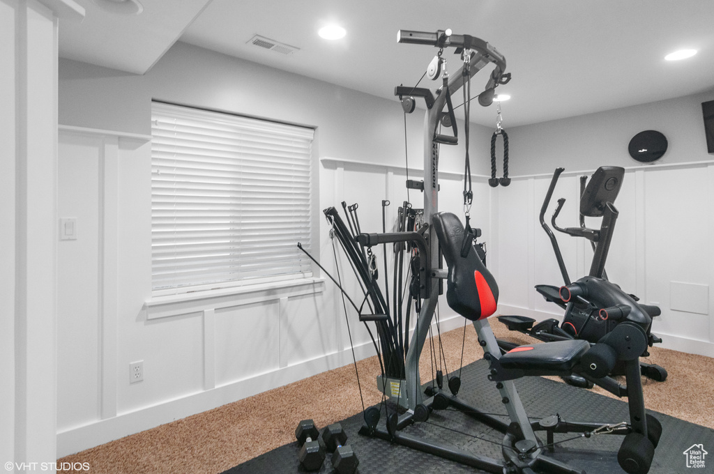 Workout room featuring a decorative wall, carpet flooring, recessed lighting, and visible vents