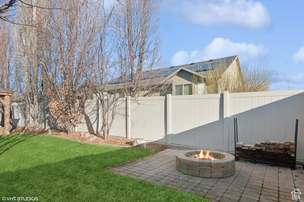 View of yard featuring a patio, a fenced backyard, and an outdoor fire pit