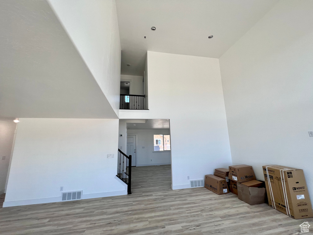 Living room featuring light hardwood / wood-style floors and a high ceiling