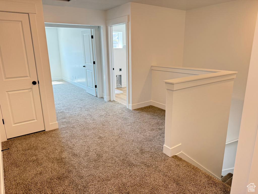 Corridor featuring carpet flooring, baseboards, and an upstairs landing