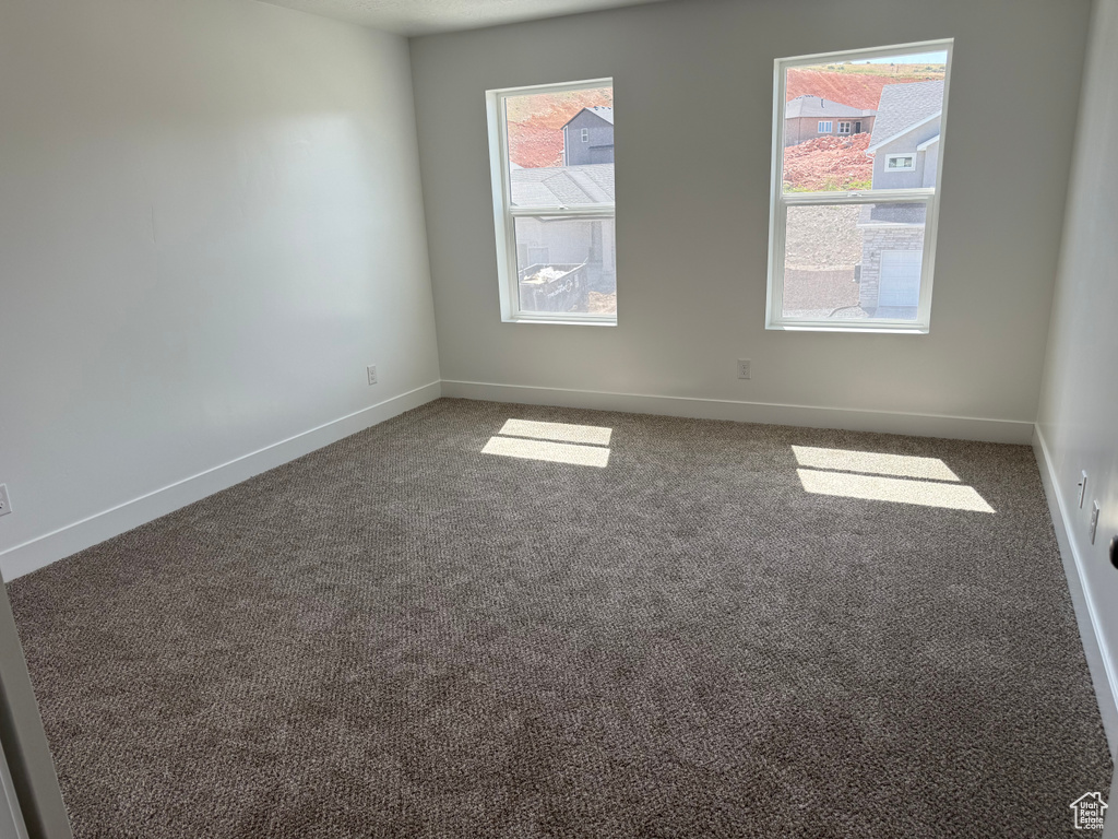 Unfurnished room with plenty of natural light, carpet, and baseboards