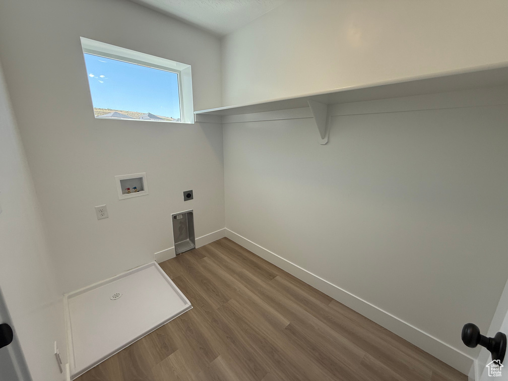 Washroom with washer hookup, wood finished floors, hookup for an electric dryer, and baseboards