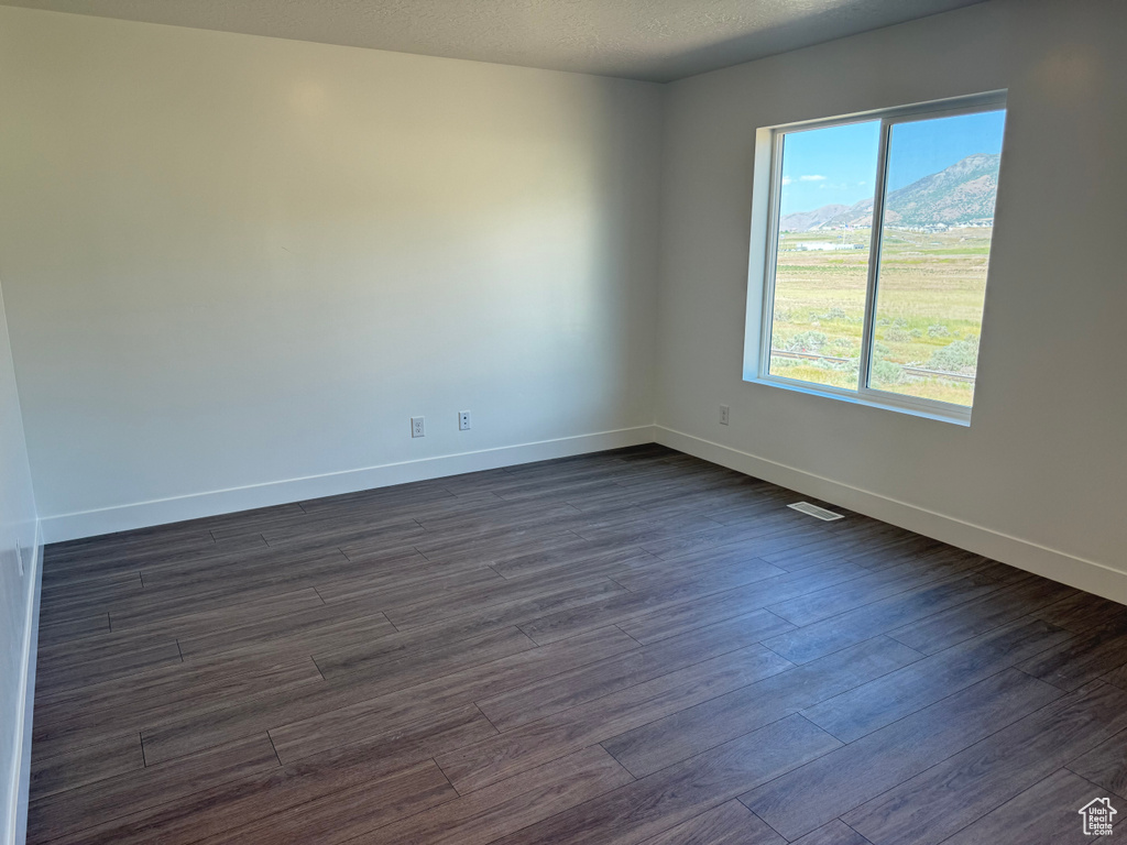 Empty room with baseboards and dark wood finished floors