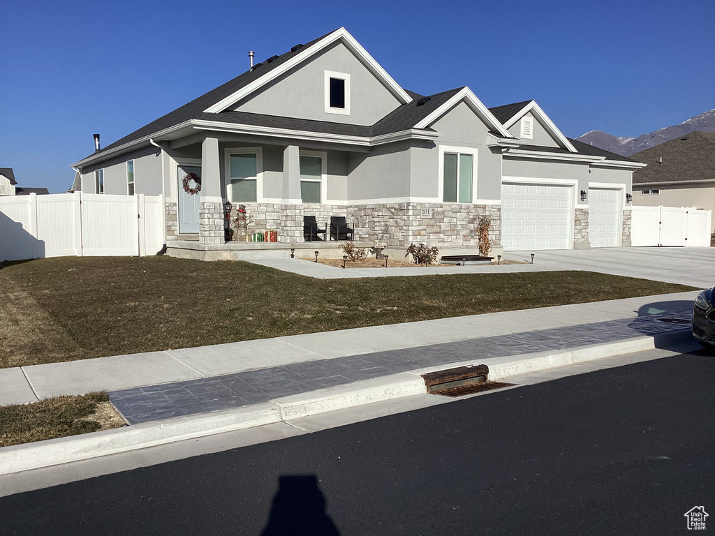 View of front of home with a front yard and a garage