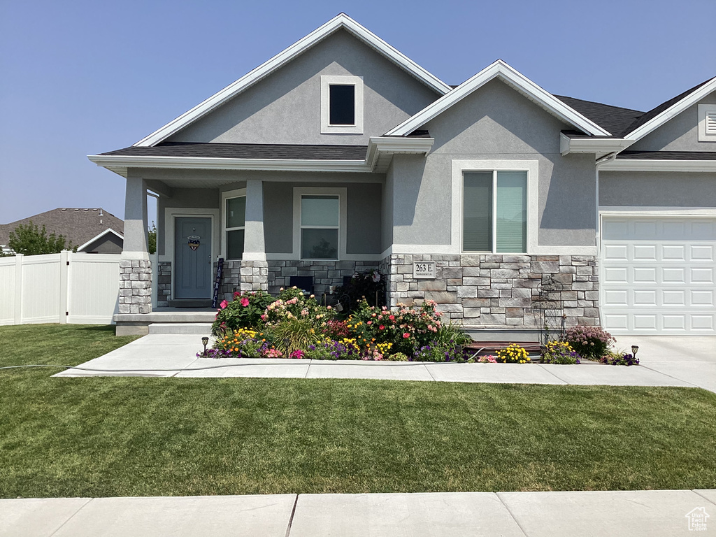 View of front of house featuring a front lawn and a garage