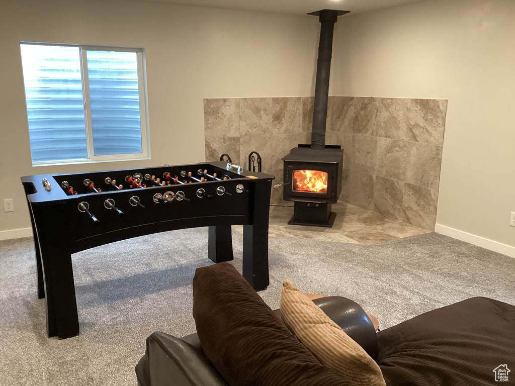 Rec room featuring carpet flooring and a wood stove