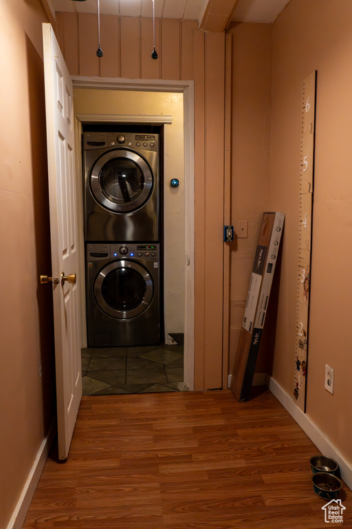 Laundry area featuring light wood-type flooring and stacked washing maching and dryer