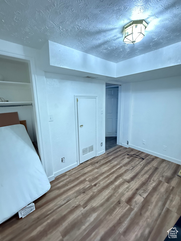 Unfurnished bedroom featuring a textured ceiling and wood-type flooring