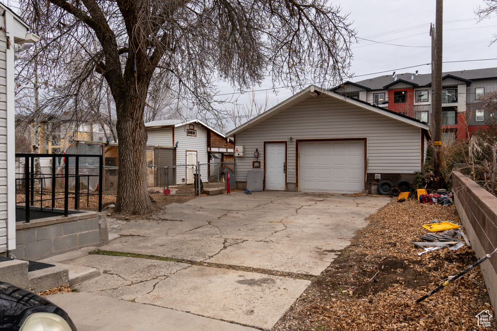 View of front facade featuring a garage and an outbuilding