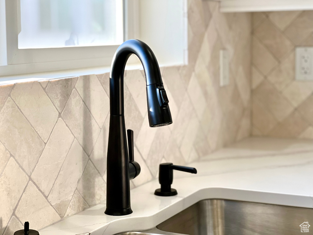 Room details featuring sink and backsplash