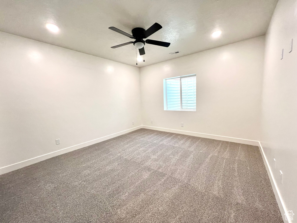 Spare room featuring ceiling fan and carpet