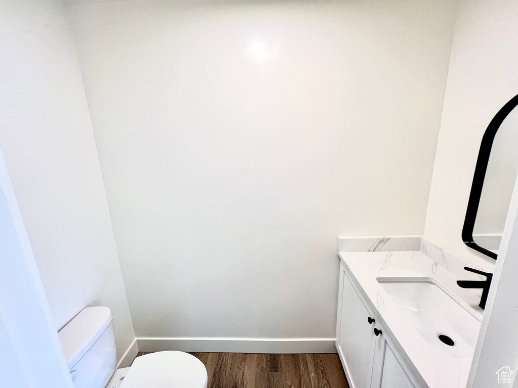 Bathroom with toilet, hardwood / wood-style flooring, and vanity