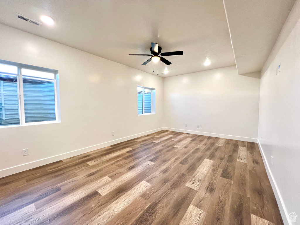 Empty room with hardwood / wood-style floors and ceiling fan