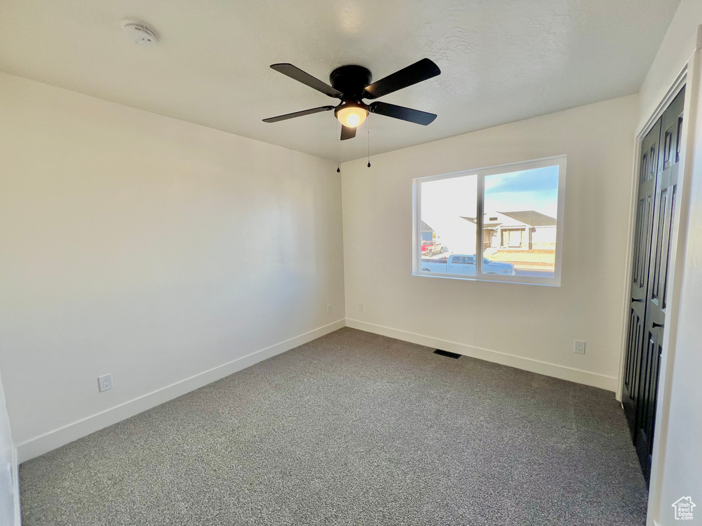 Unfurnished bedroom with carpet and ceiling fan