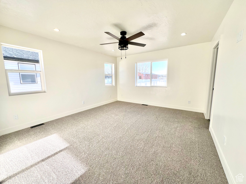 Unfurnished room with ceiling fan and carpet