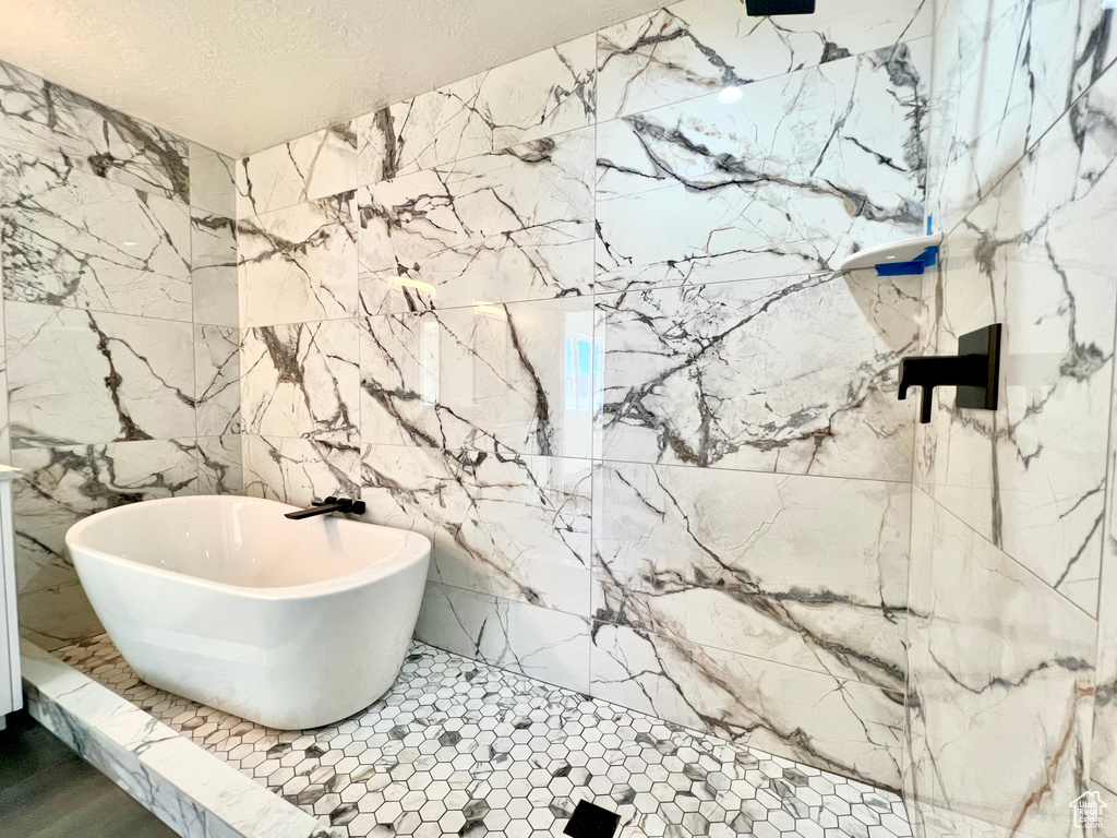 Bathroom featuring a tub and a textured ceiling