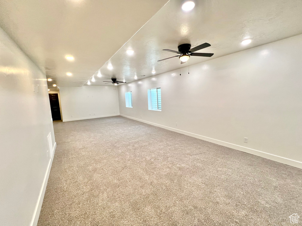 Basement featuring ceiling fan and carpet flooring