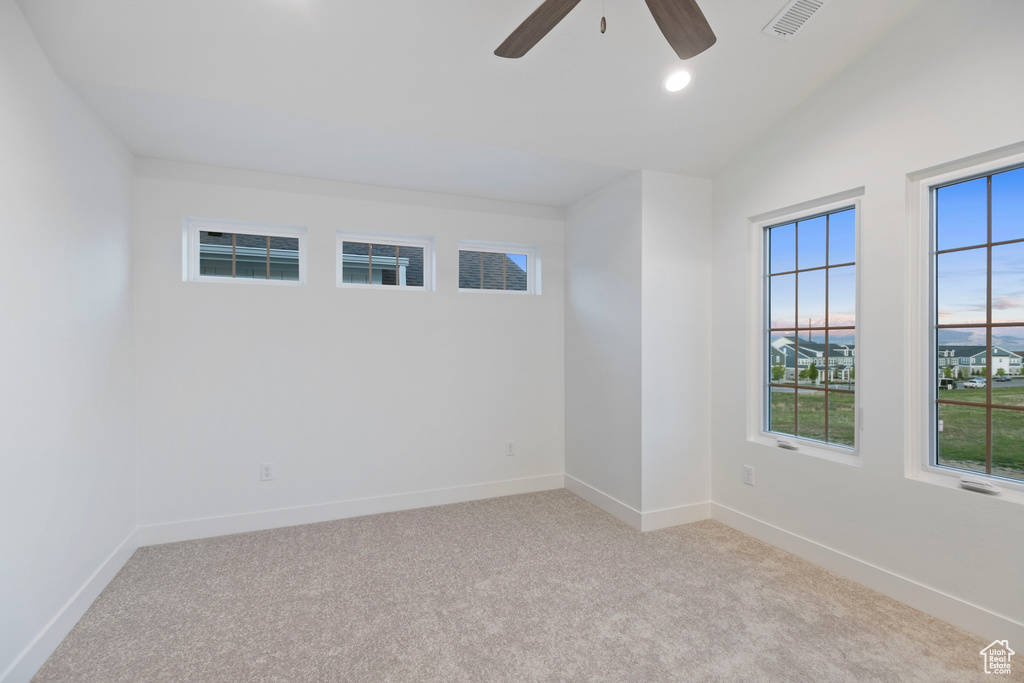 Carpeted spare room with ceiling fan, baseboards, and recessed lighting
