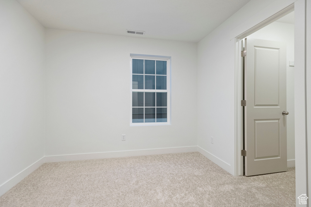 Empty room featuring carpet flooring and baseboards
