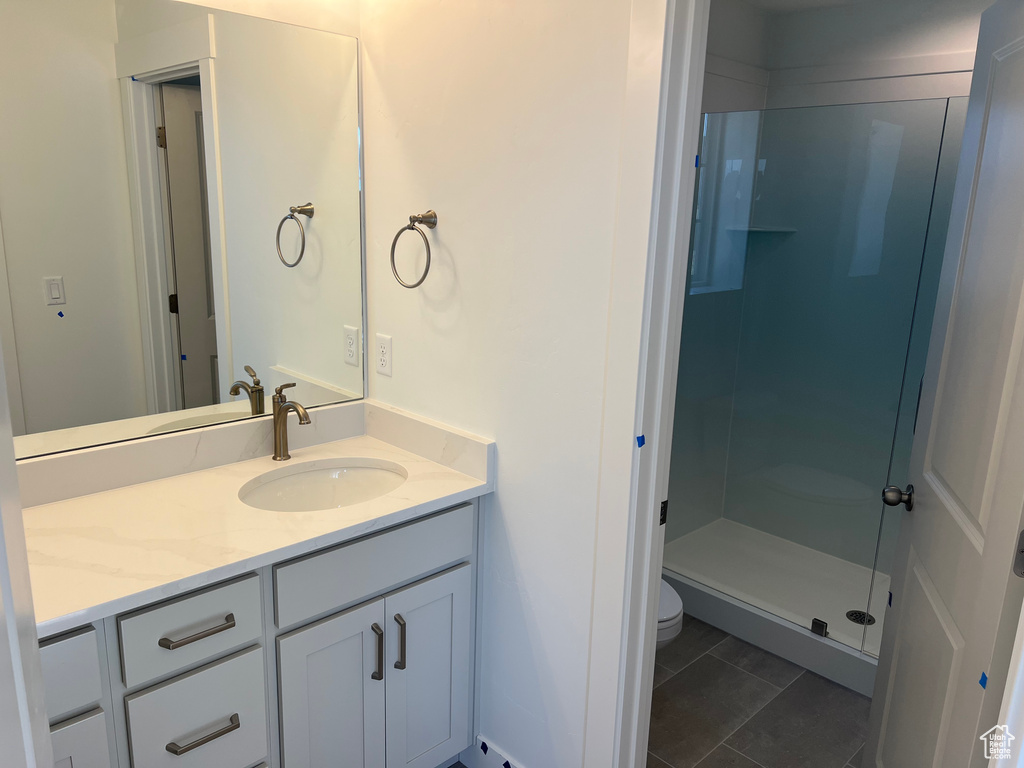 Full bath with tile patterned flooring, toilet, a stall shower, and vanity