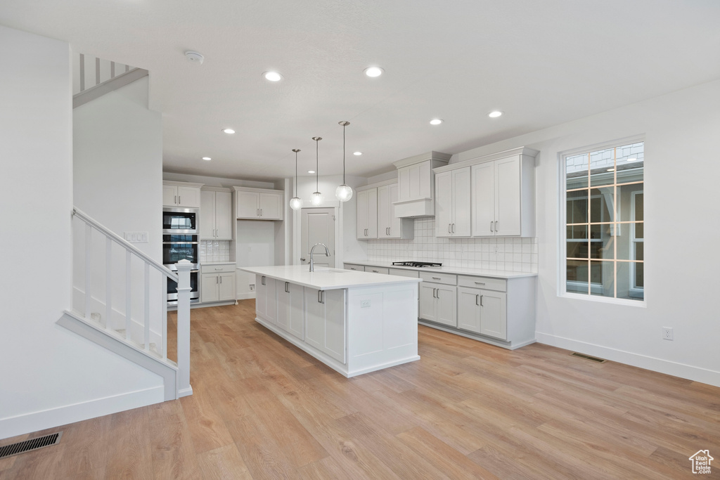 Kitchen with stainless steel appliances, recessed lighting, a sink, tasteful backsplash, and light countertops