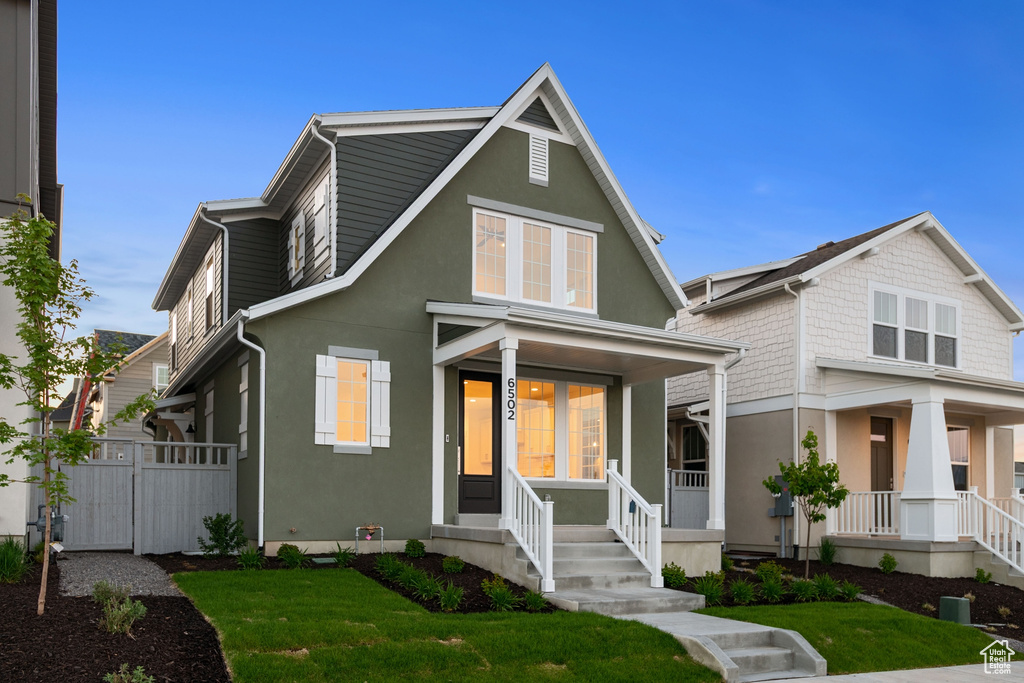 View of front facade with a porch and stucco siding