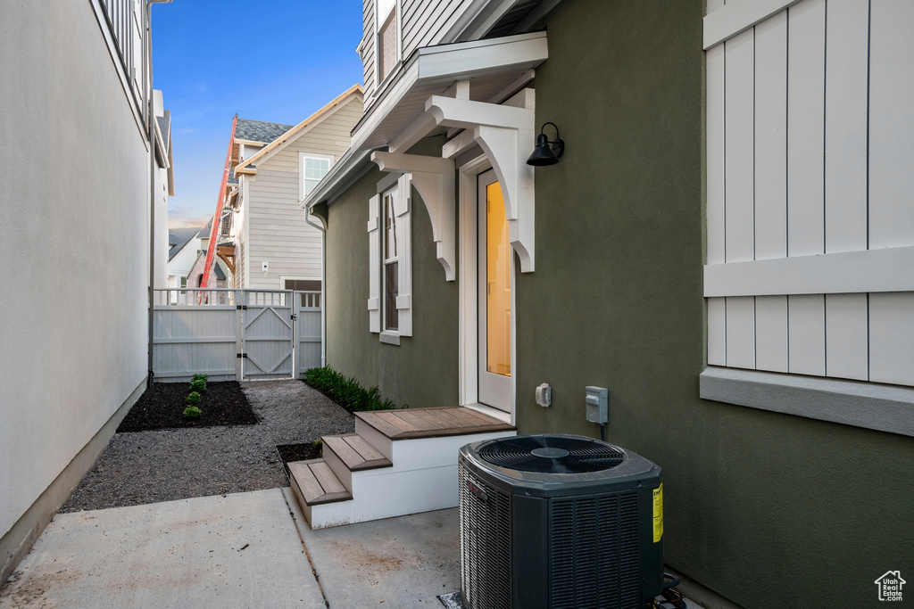 View of patio with central air condition unit, a gate, and fence