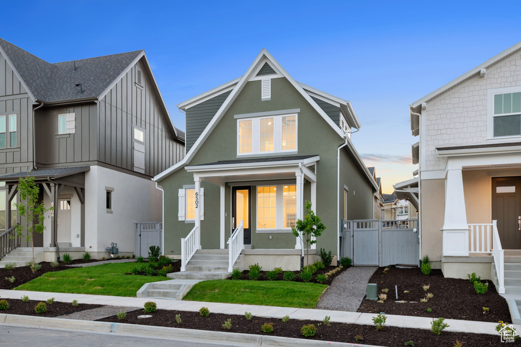 View of front of home featuring a gate, stucco siding, and a front lawn