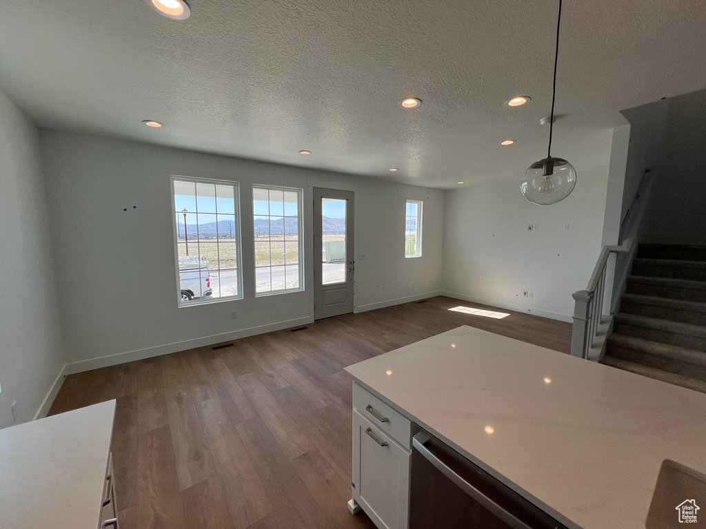Kitchen featuring dark wood-style flooring, recessed lighting, light countertops, white cabinetry, and a textured ceiling
