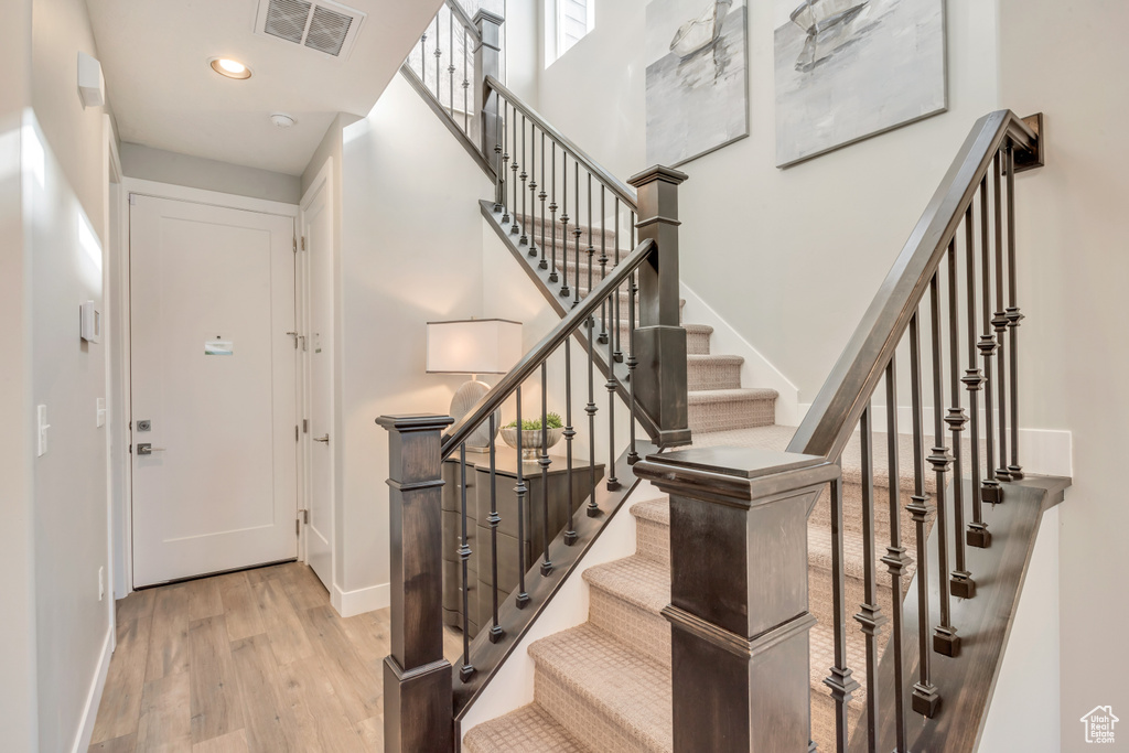 Stairs featuring hardwood / wood-style flooring