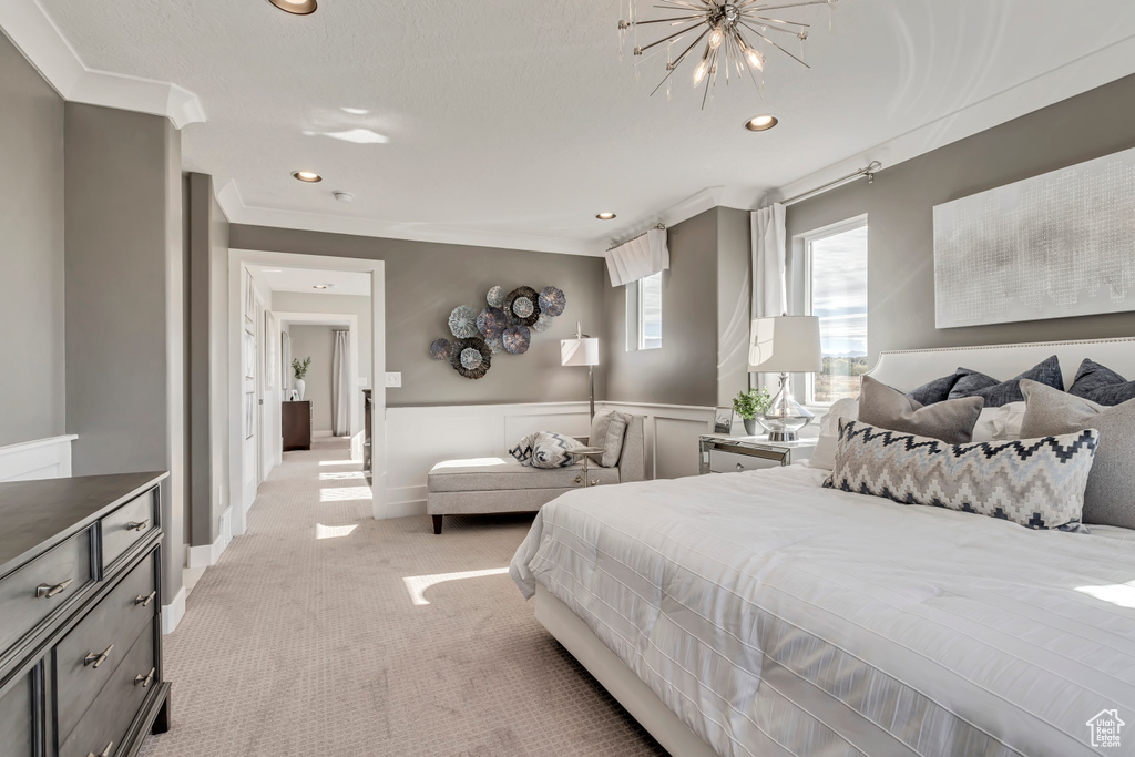 Bedroom with light carpet, a notable chandelier, and ornamental molding