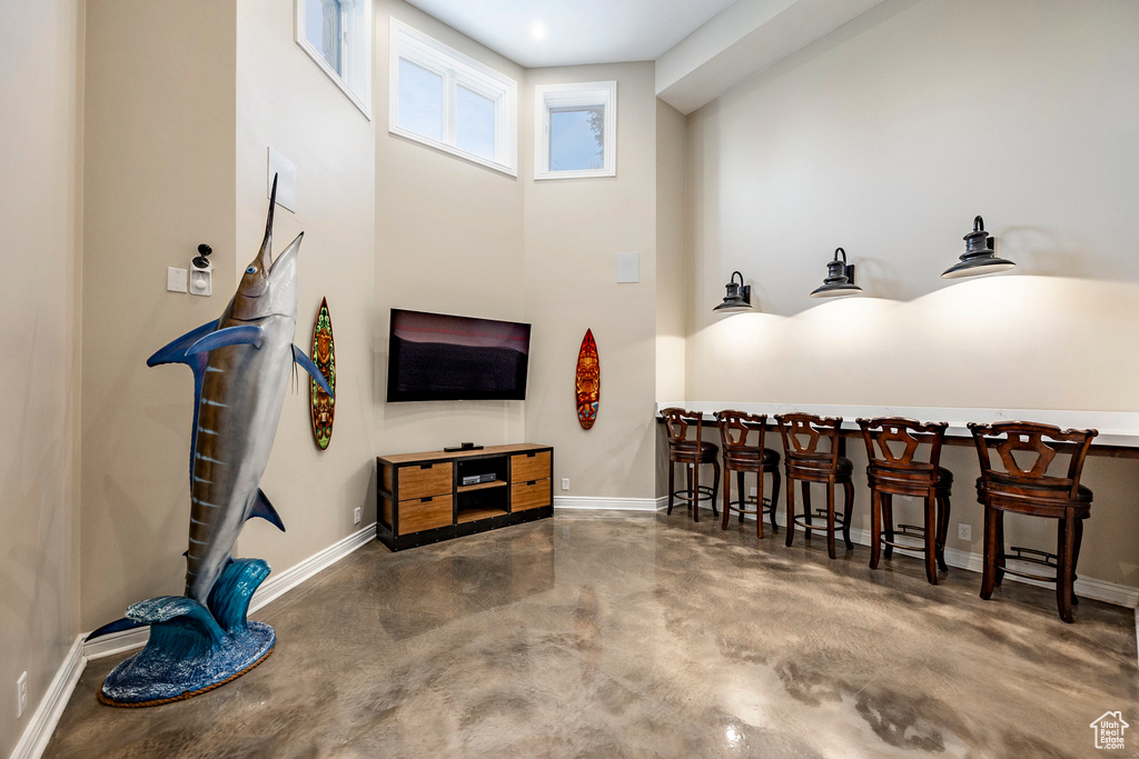 Living room featuring finished concrete floors and baseboards