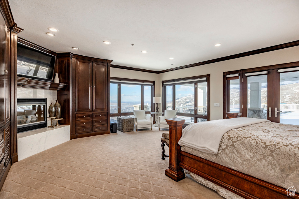 Bedroom with access to outside, ornamental molding, french doors, recessed lighting, and light colored carpet