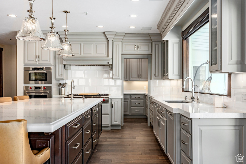 Kitchen with gray cabinetry, a sink, dark wood finished floors, recessed lighting, and tasteful backsplash