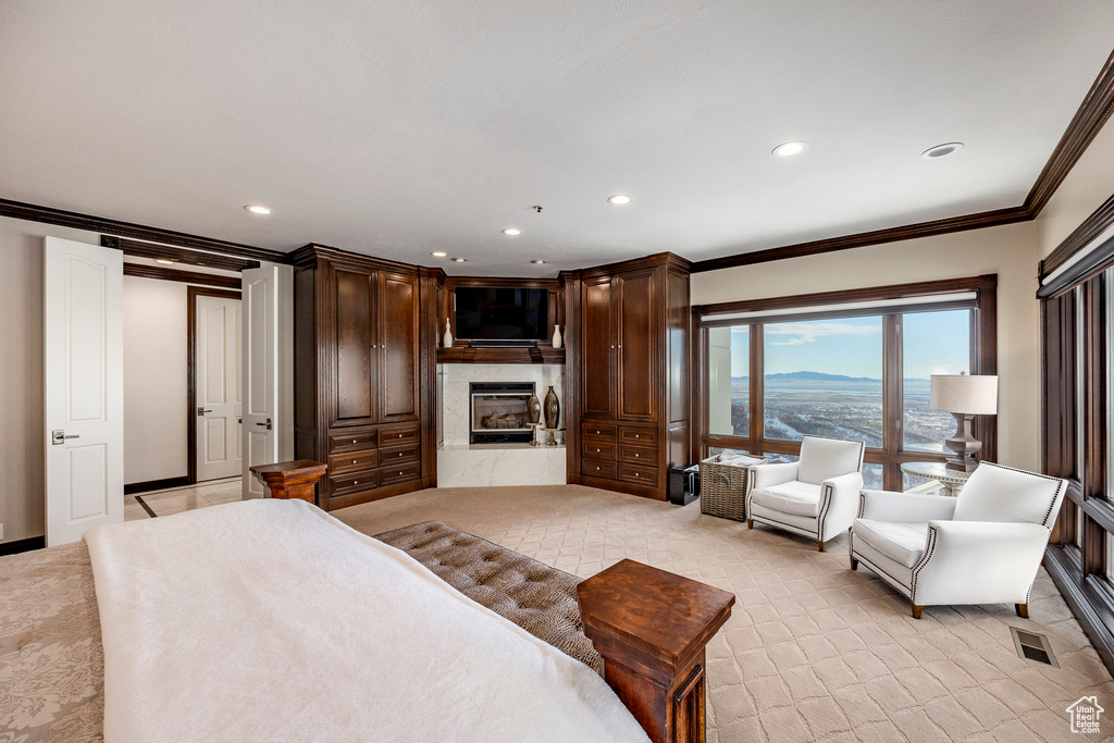 Bedroom featuring ornamental molding, a glass covered fireplace, recessed lighting, and baseboards
