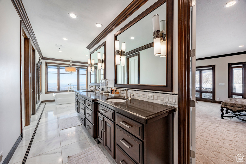 Full bath featuring crown molding, baseboards, a freestanding bath, tasteful backsplash, and recessed lighting