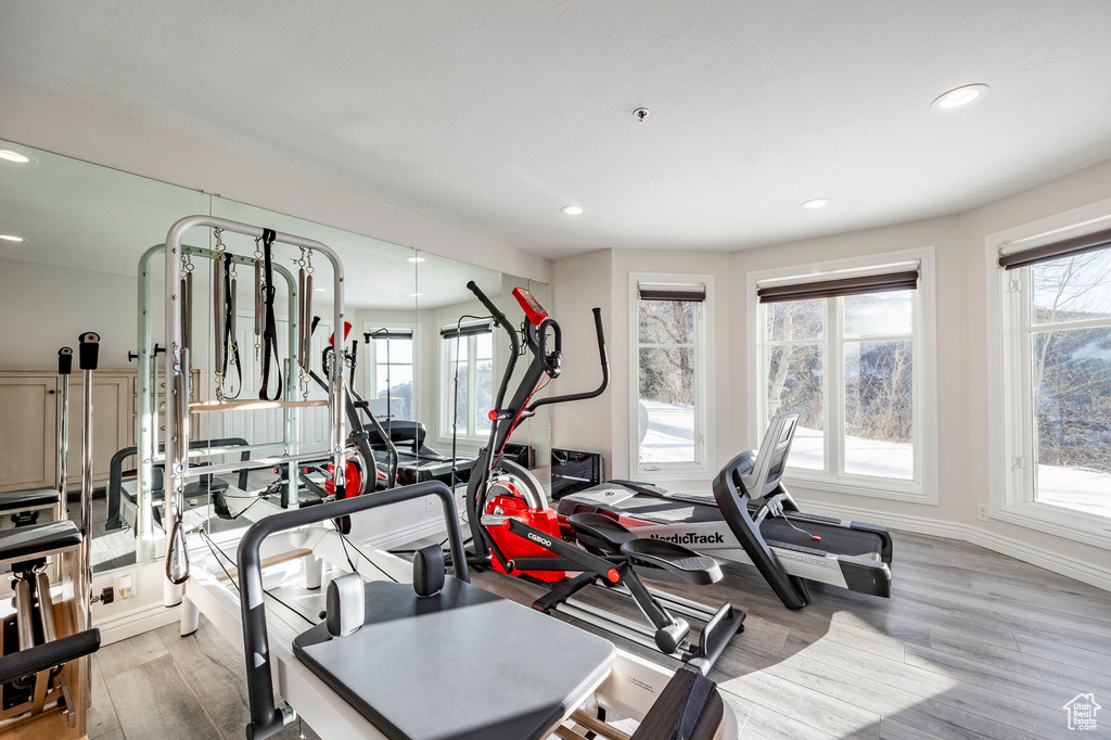 Workout area with light wood-style flooring, recessed lighting, and baseboards