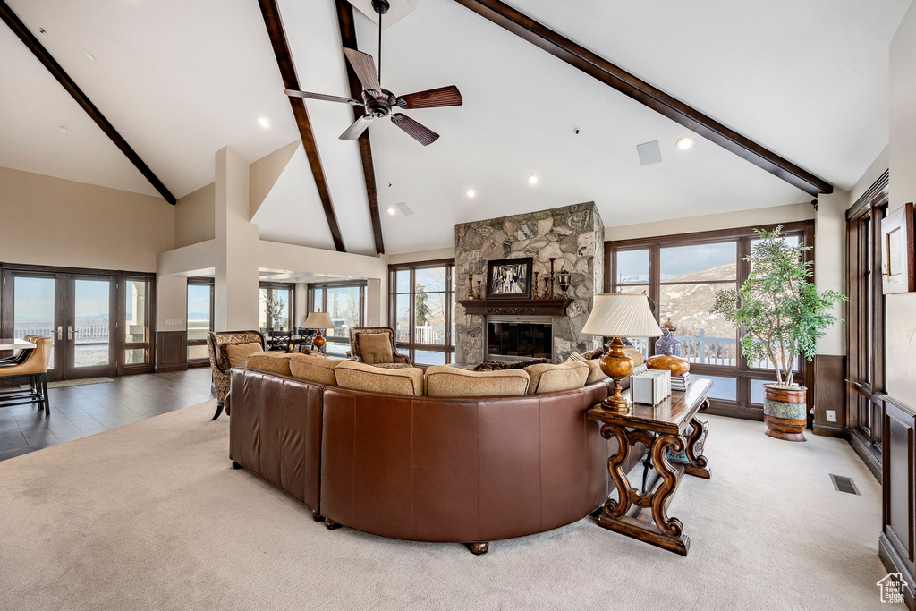 Living area with beam ceiling, a fireplace, high vaulted ceiling, french doors, and a ceiling fan