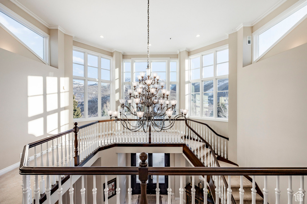 Stairs featuring a chandelier, ornamental molding, a towering ceiling, recessed lighting, and baseboards