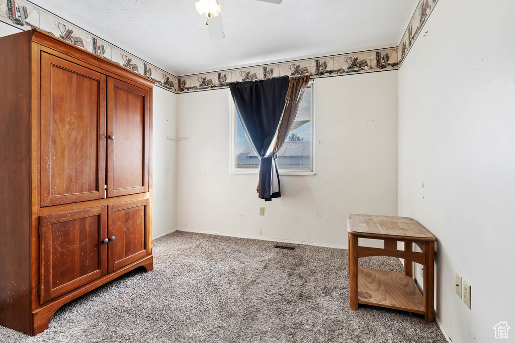 Interior space with light carpet and ceiling fan